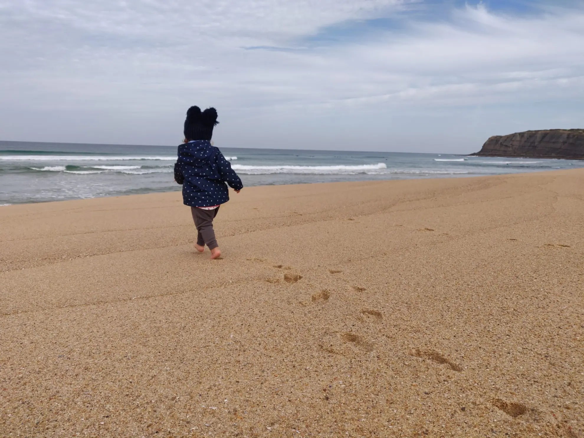 child walking barefoot at the beach